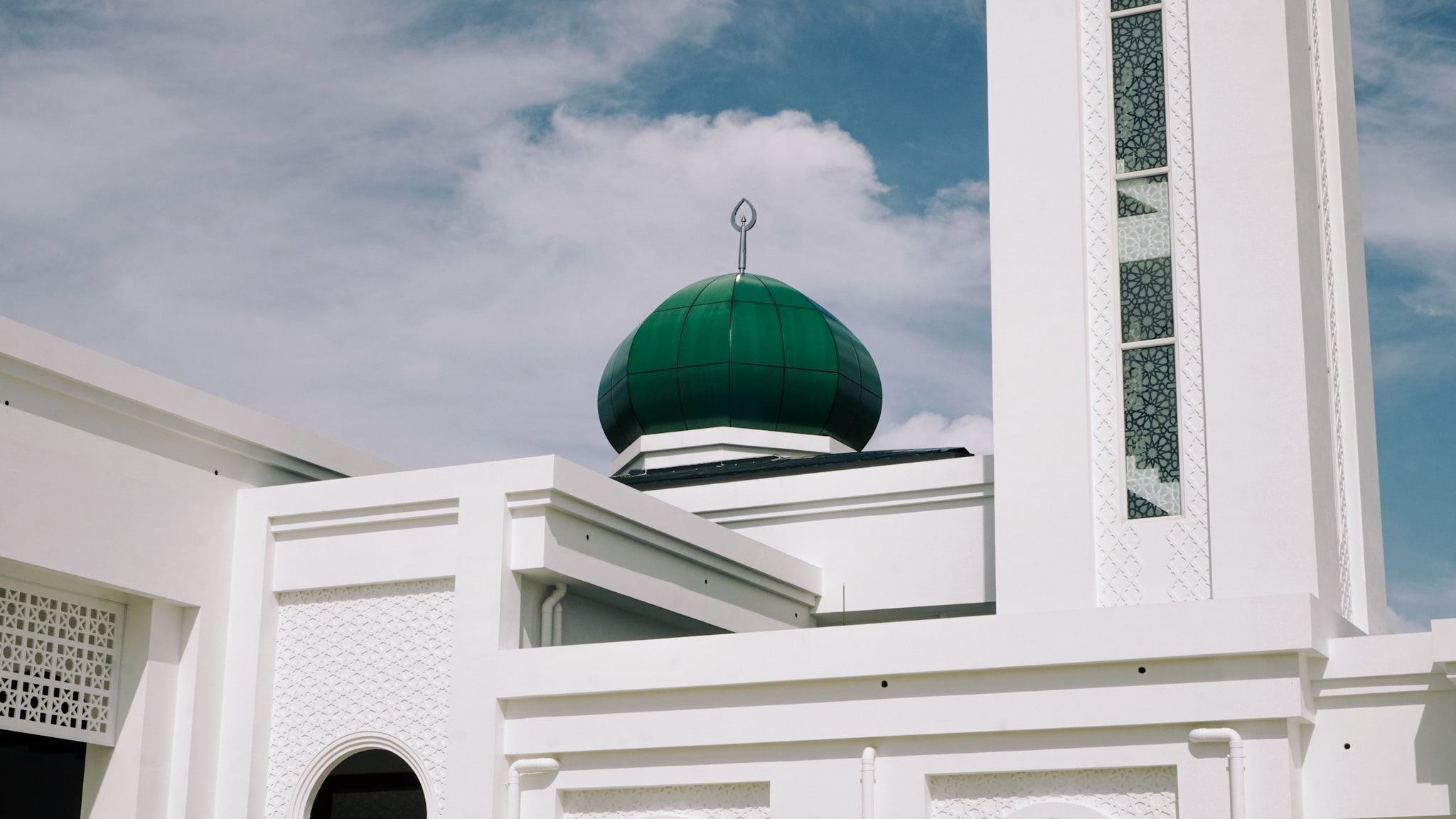 The green dome and the patterned minaret shaft of Masjid Baru RPN Kg Rimba against the sky